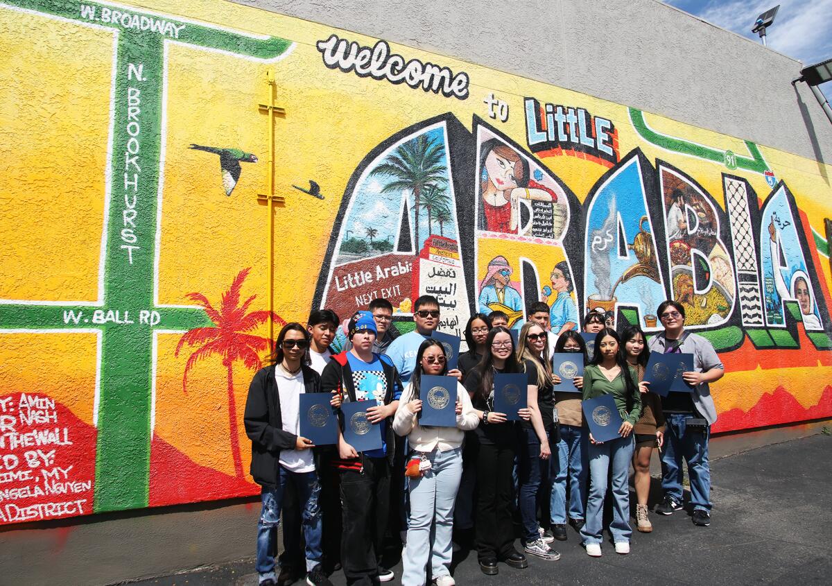 Magnolia High School art students pose in front of the mural during the dedication ceremony.