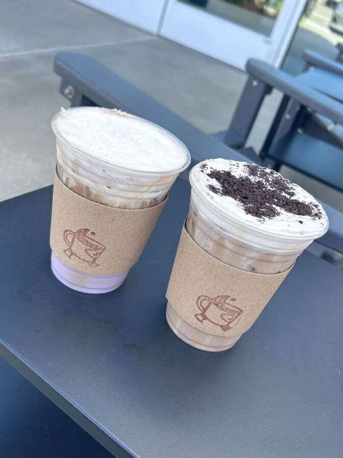 photo of two lattes, both of which contain foam and purple syrup mixed in.