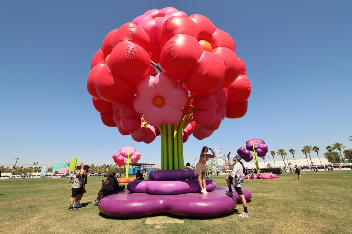 People at the flower installation at the 2025 Coachella Vally Arts and Music Festival in Indio.