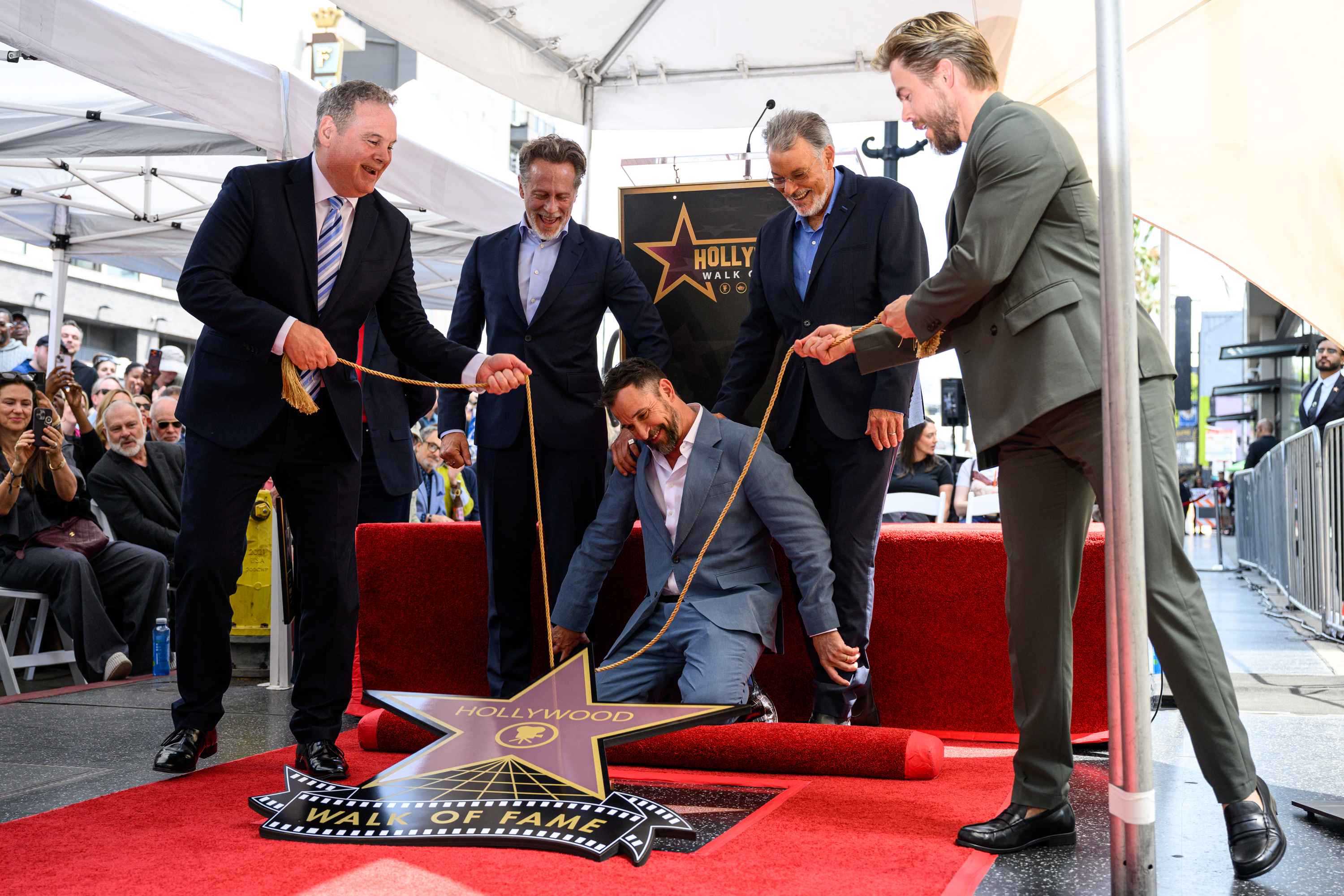 Noah Wyle kneels on the ground for the unveilling of...