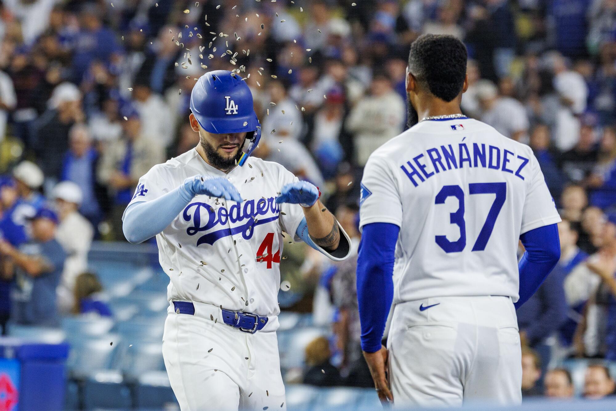 Teoscar Hernandez tosses sunflower seeds at Andy Pages after Pages hit a two-run homer in the eighth inning.
