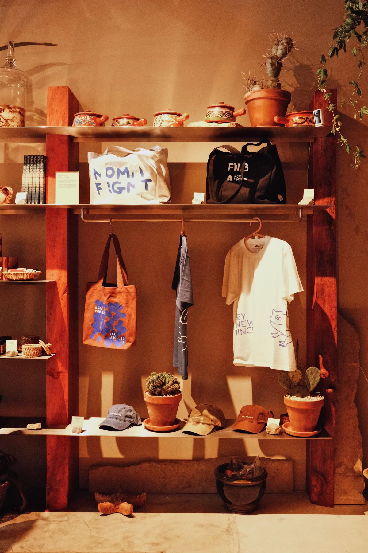T-shirts, tote bags and hats on shelves in the Noma Projects pop-up shop in Silver Lake