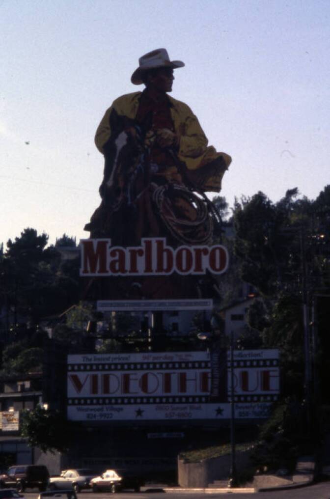 A giant billboard of a cowboy riding a horse for Marlboro cigarettes.