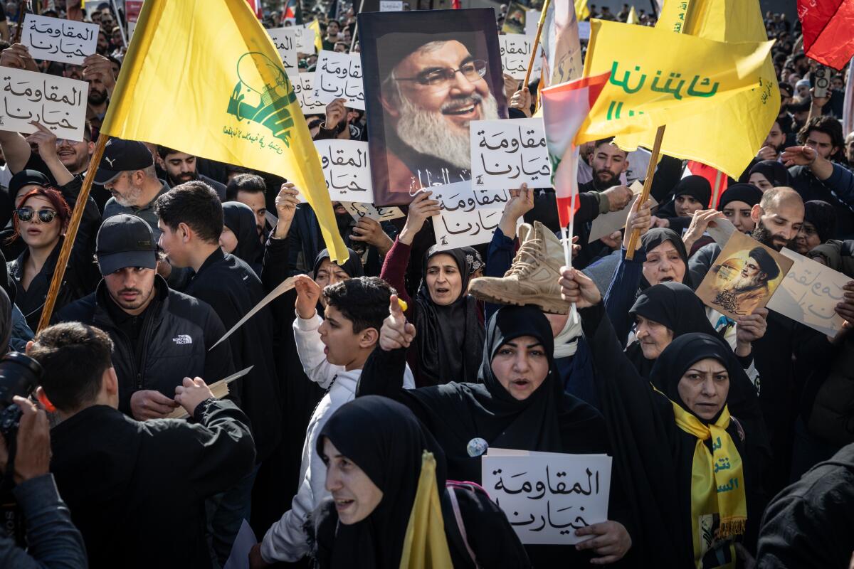 Hezbollah supporters chant slogans and wave flags and posters during an anti-government protest