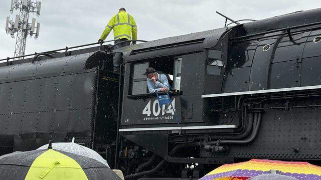 A crew member looks out from the cab of Union Pacific Railroad’s Big Boy No. 4014 as another worker stands atop the hulking steam locomotive along Atlantic Street in Roseville’s historic district on Friday, April 10, 2026. After its Roseville stop, the train is scheduled to continue to Colfax and Truckee before heading east into Nevada.