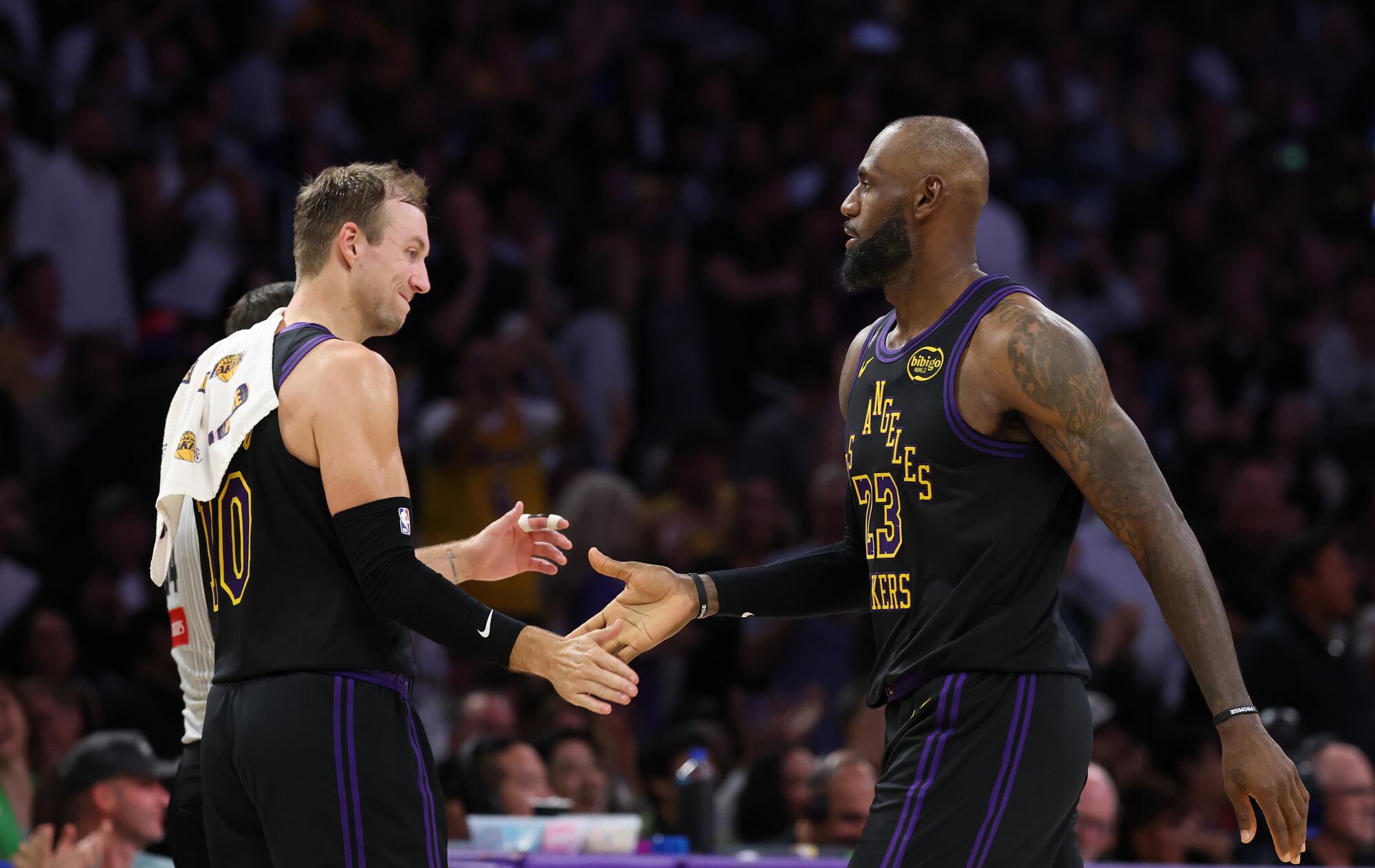 Lakers guard Luke Kennard extends his arm to high five and celebrate forward LeBron James' made basket.