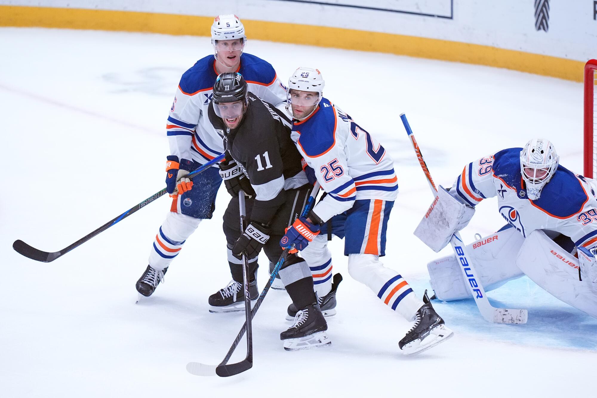 The Kings' Anze Kopitar vies for position in front of the Oilers' Darnell Nurse on Saturday.