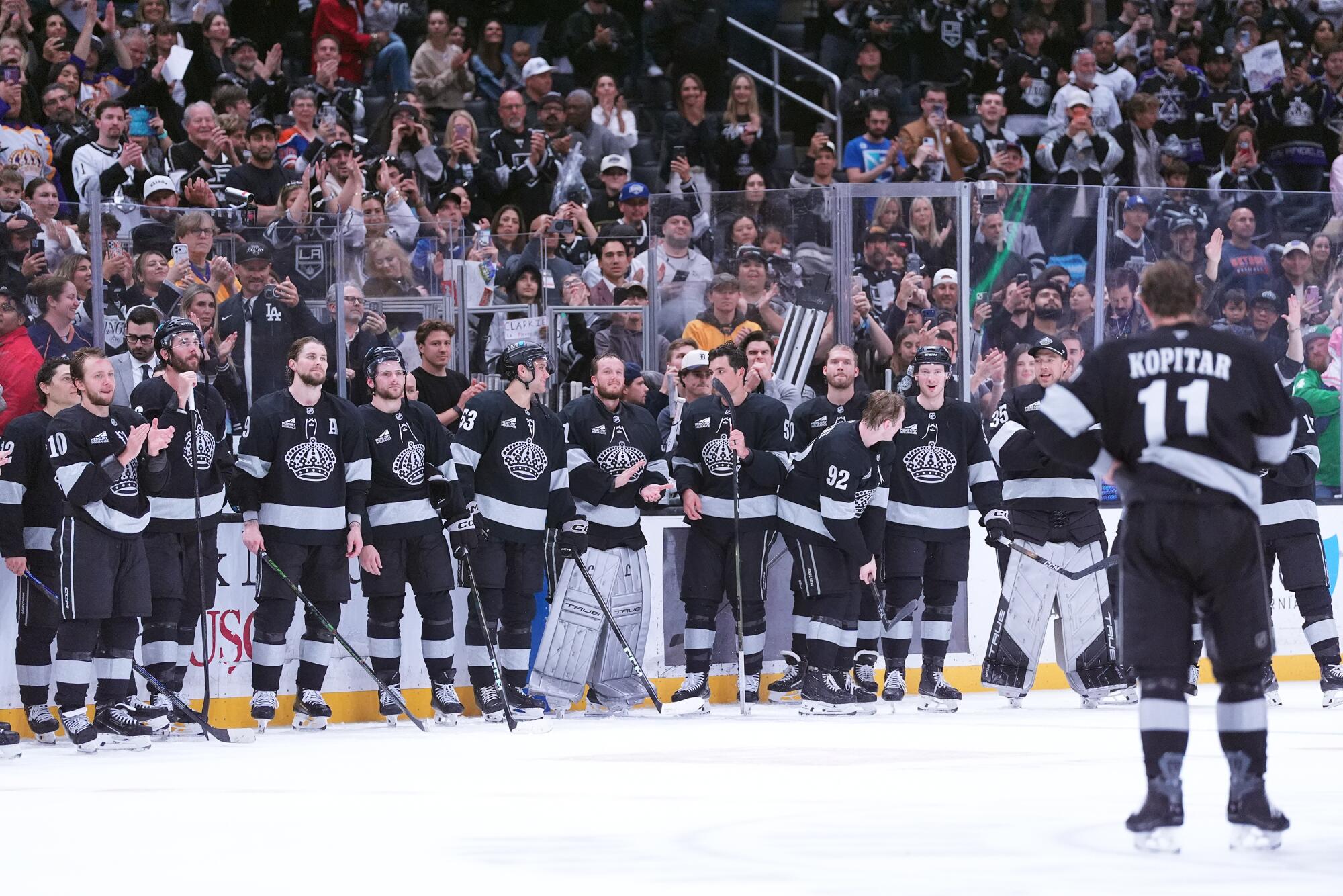Kings players react as Anze Kopitar speaks to fans after his final regular-season home game.