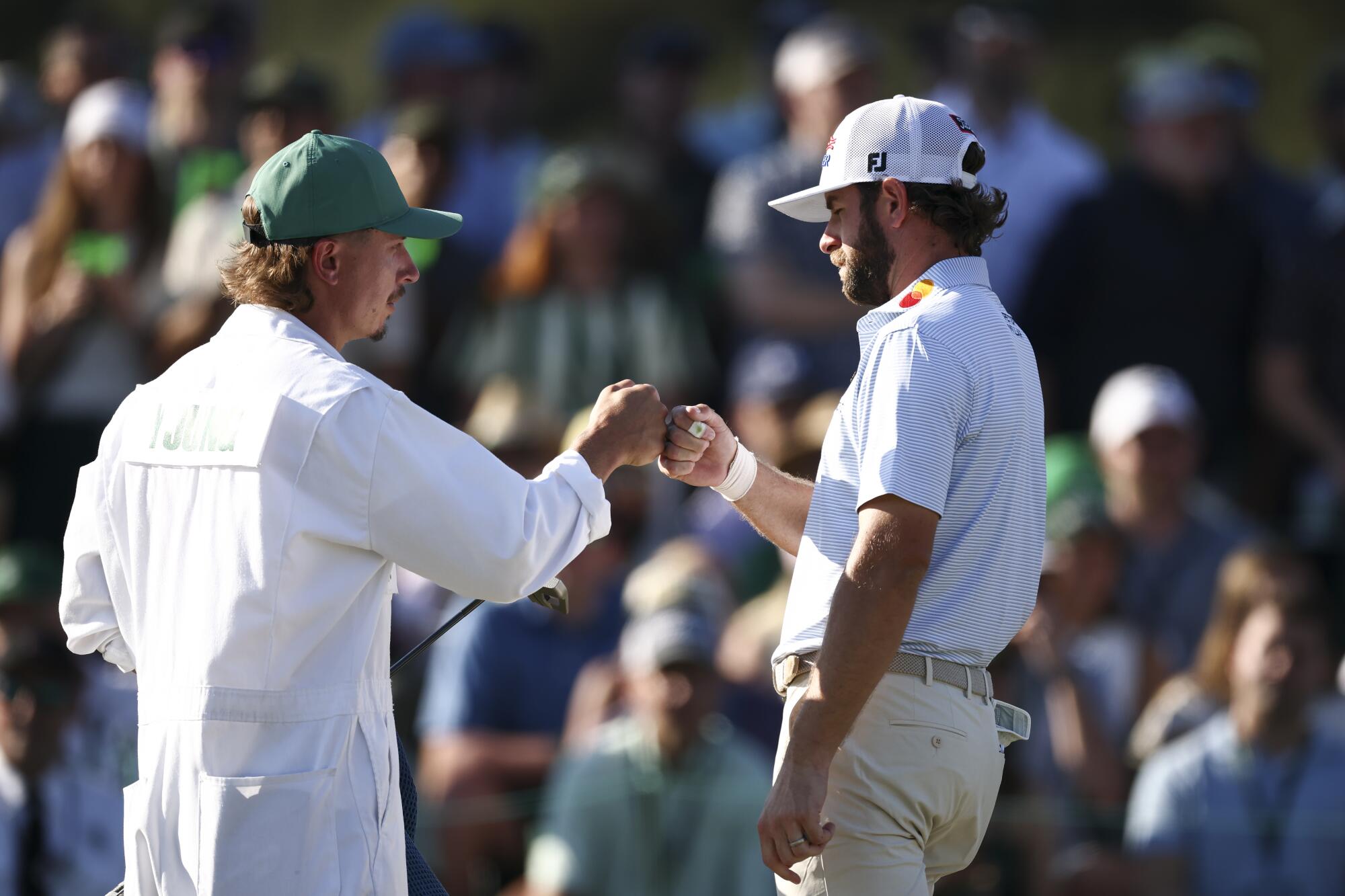 Cameron Young fist bumps his caddie, Kyle Sterbinsky, on the 18th green during the third round of the Masters.