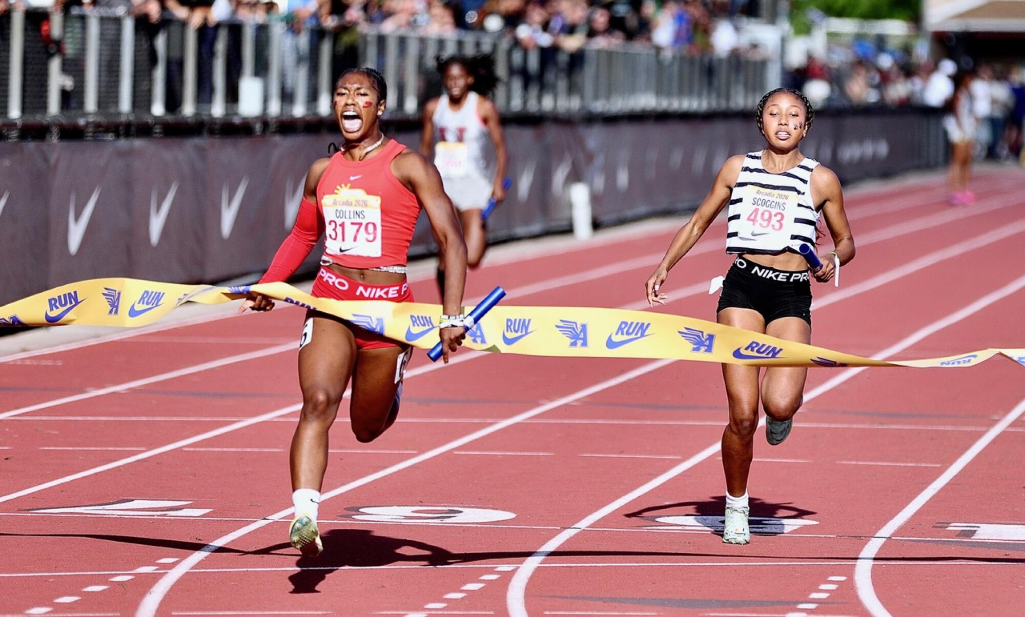 Rosary’s Maliyah Collins (left) breaks the tape ahead of Calabasas’ Marley Scoggins in the girls’ 4x100 relay.