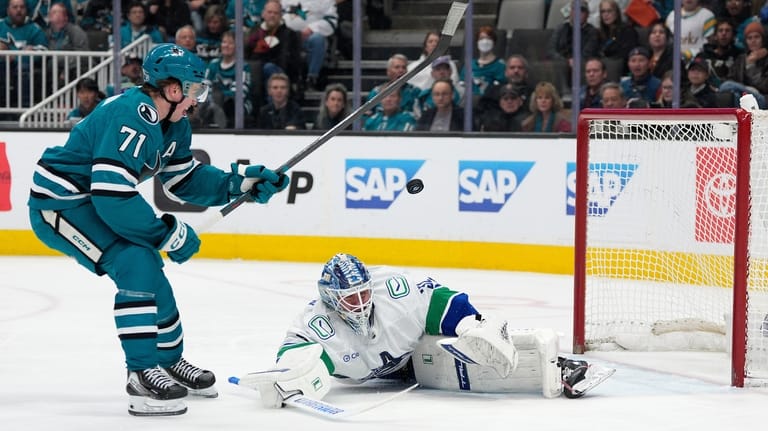 Vancouver Canucks goaltender Kevin Lankinen, right, blocks a shot by...