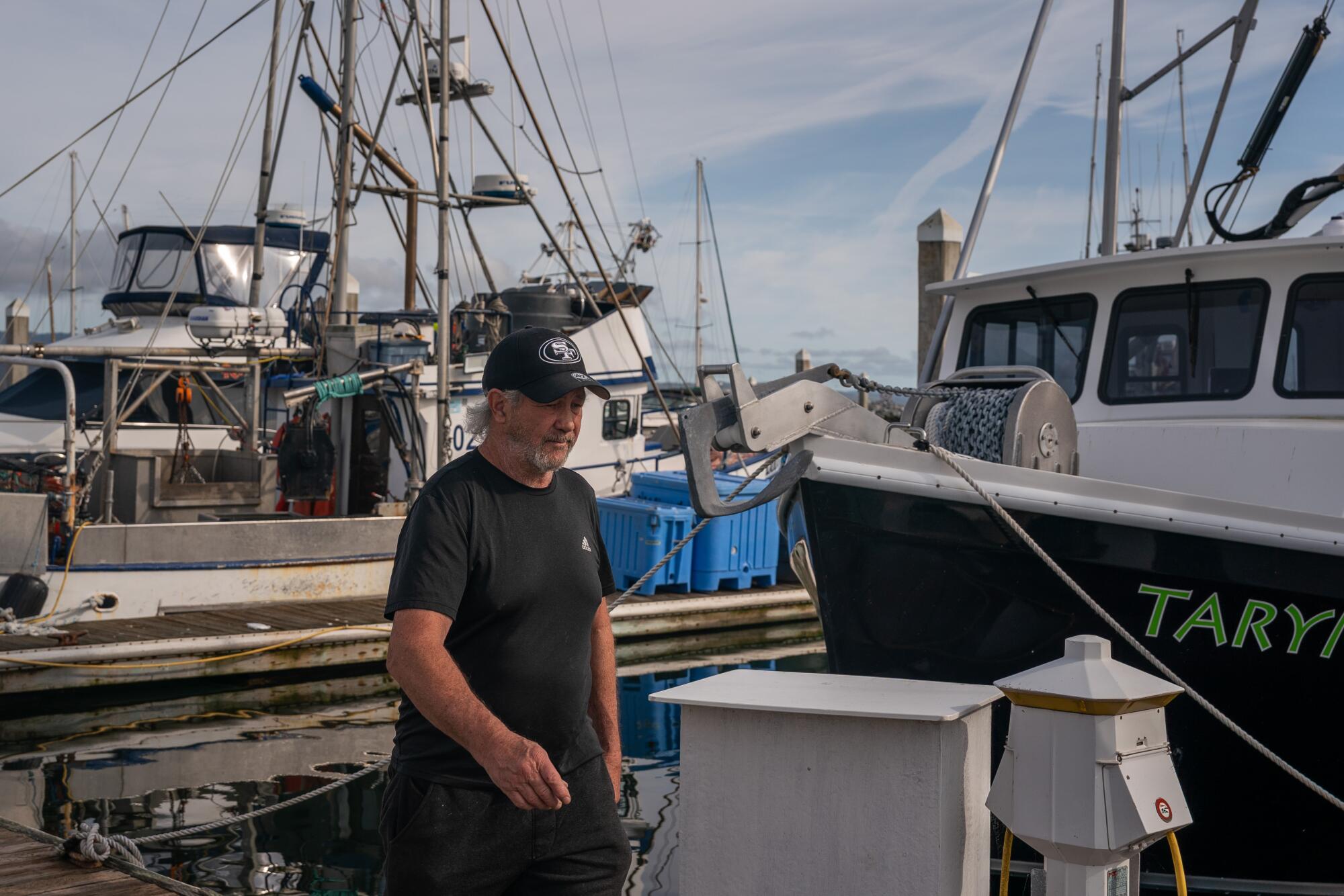 Fisherman Chris Pedersen walks on a dock in Half Moon Bay in 2024. 