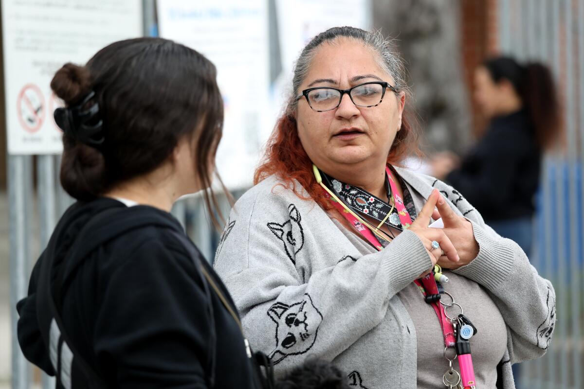 Two women talk in front of the school after dropping off their children at Parmelee Avenue Elementary School.