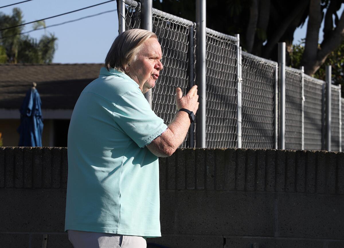 Ted Beresford explains the easement line and the property line on Rhone Lane in Huntington Beach on Tuesday.
