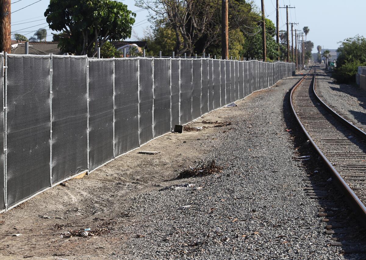 A fence runs on an alley behind Rhone Lane in Huntington Beach on Tuesday.