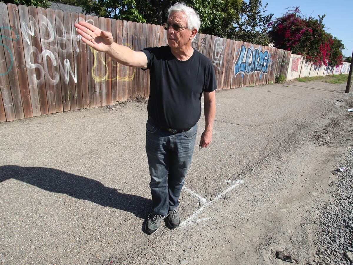 Clark Stephens points to where his property line runs along Rhone Lane in Huntington Beach.