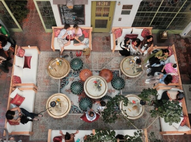 A photograph pointing down at a group of people sitting in a courtyard