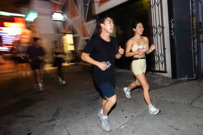 People running down a sidewalk. There's some motion blur on the left side.