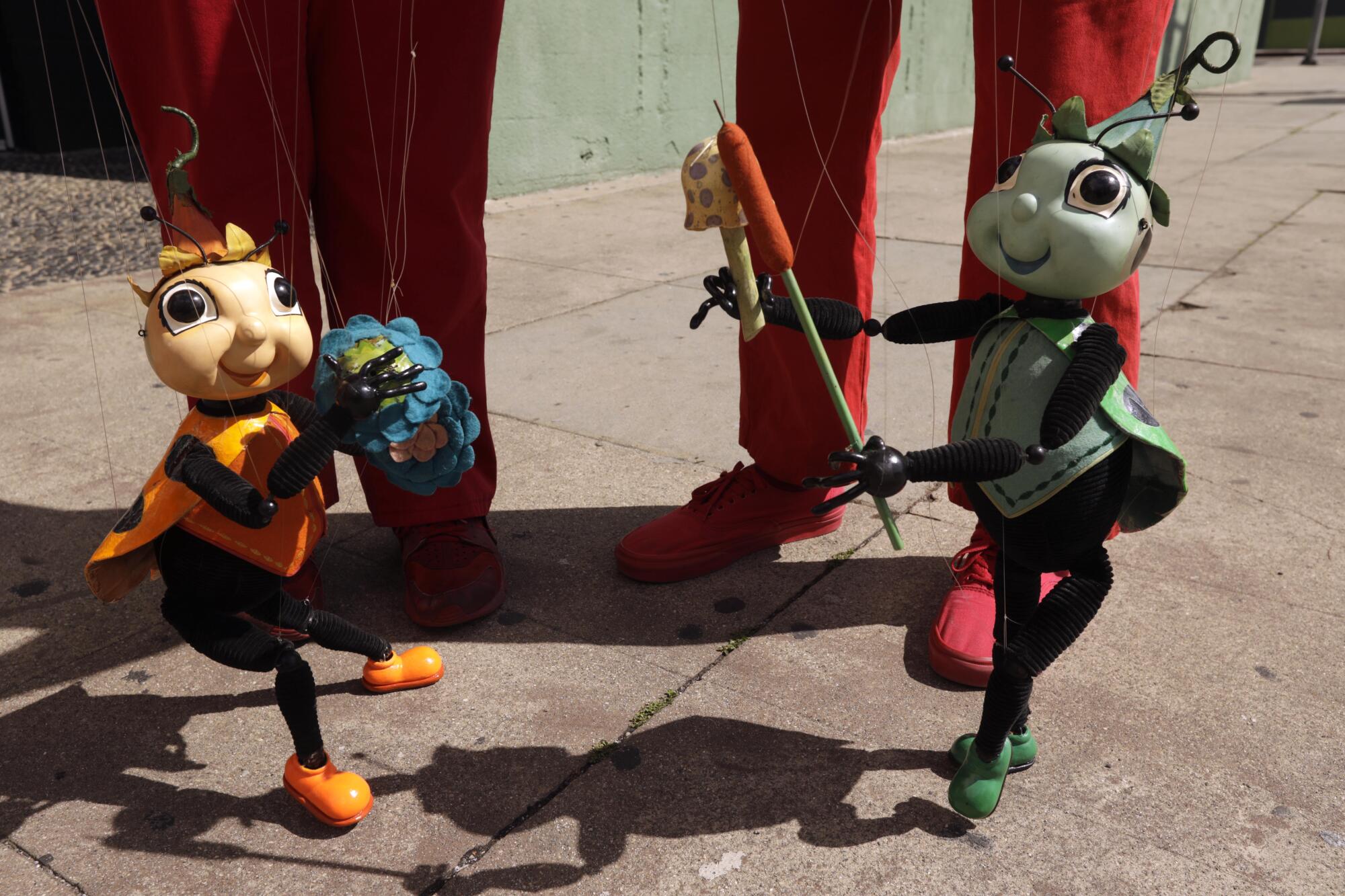 A sidewalk performance outside the Bob Baker Marionette Theater featuring ladybug puppets.