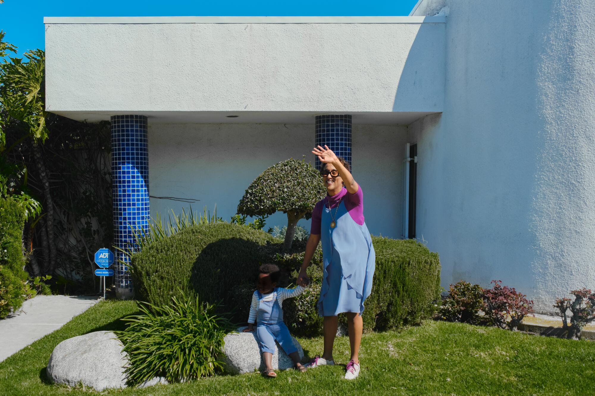 Felema and her son standing outside of her home.