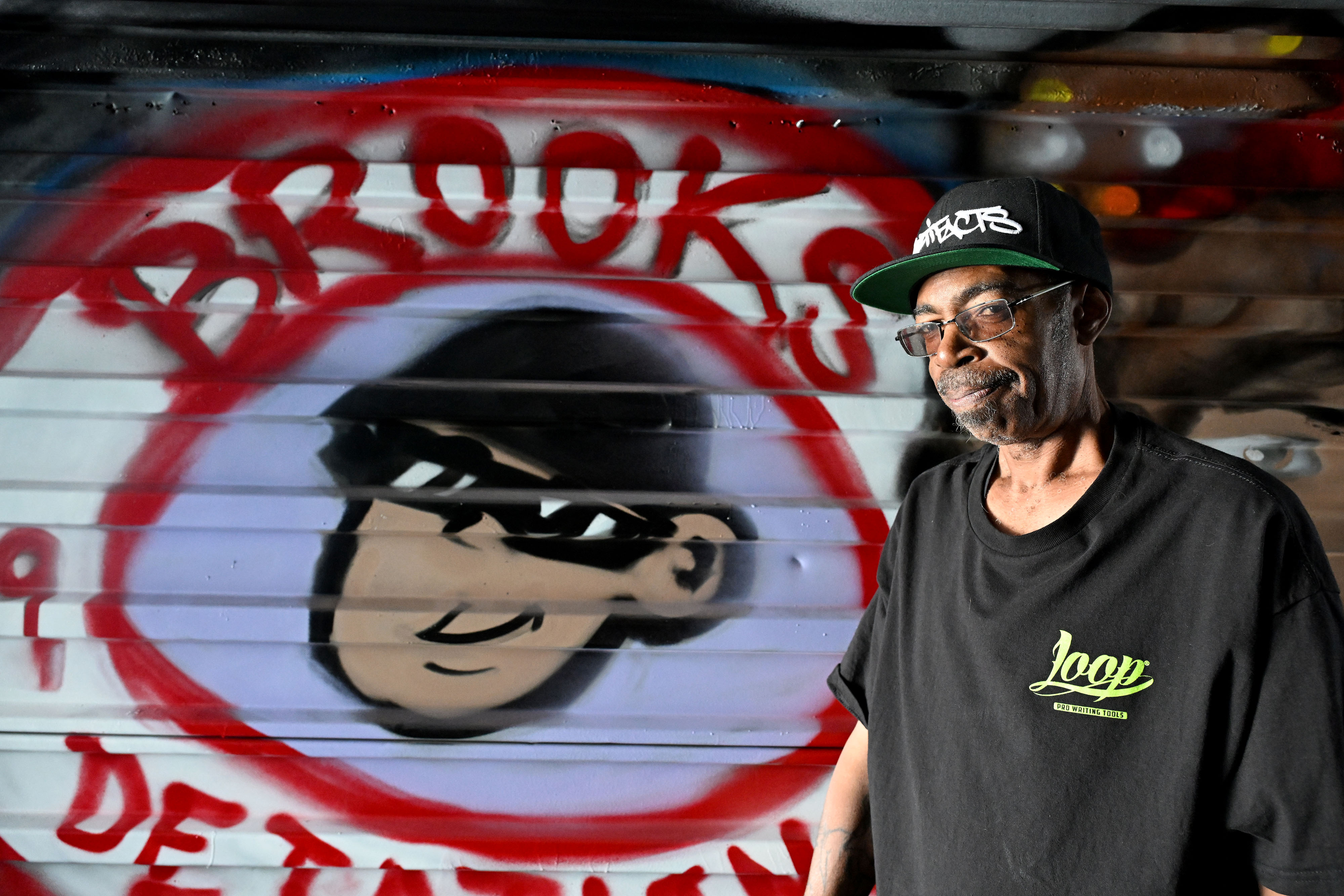 Artist, D. âZâ Brooks stands next to his mural in...