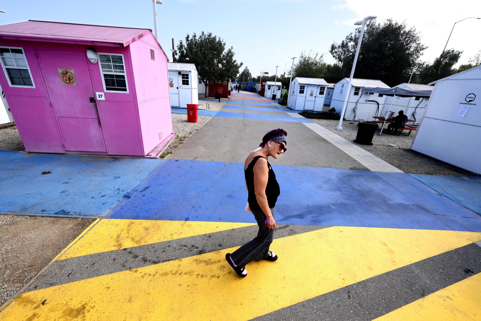 Cathy Fuller walks to her unit at Alexandria Park Tiny Home Village in North Hollywood.