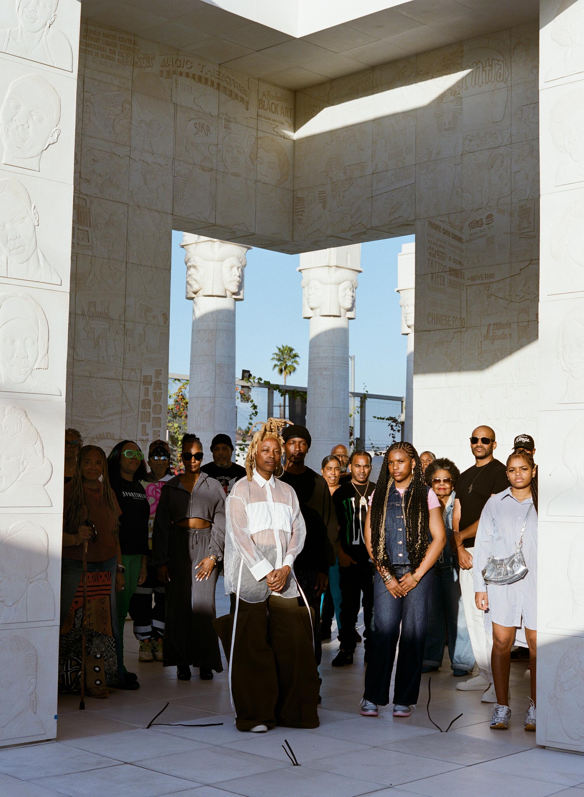 Lauren Halsey and her loved ones stand in the center of her monument in South-Central.