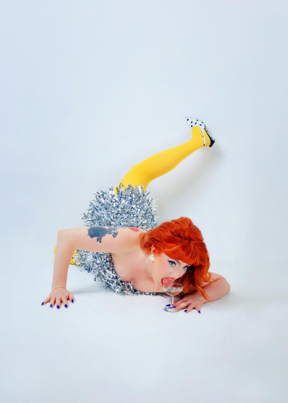 Woman with red hair and sparkly dress laying down