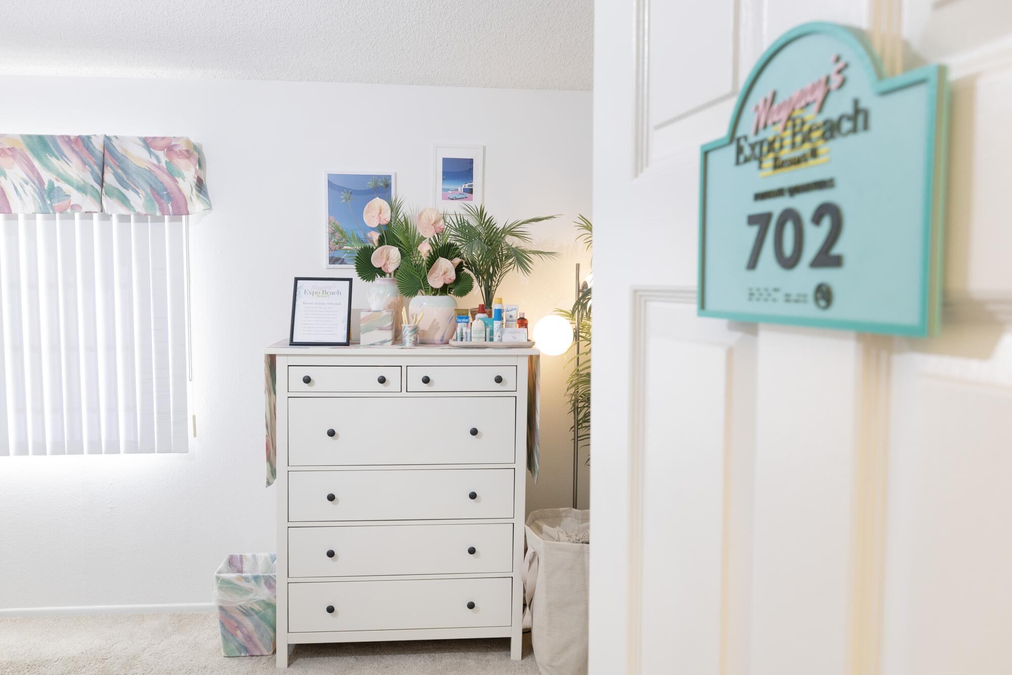 A white bedroom with a hotel sign on the door 