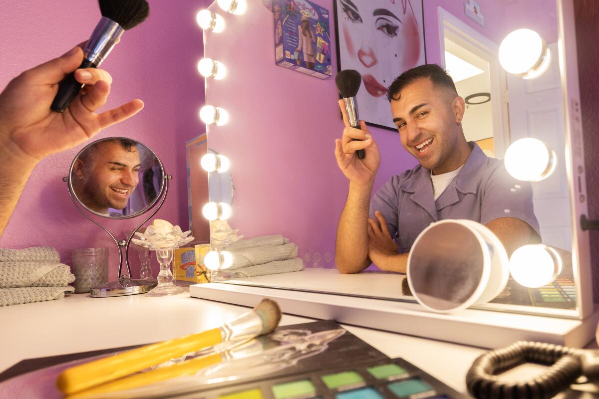 Brandon Shahniani sits in front of the mirror with some makeup.