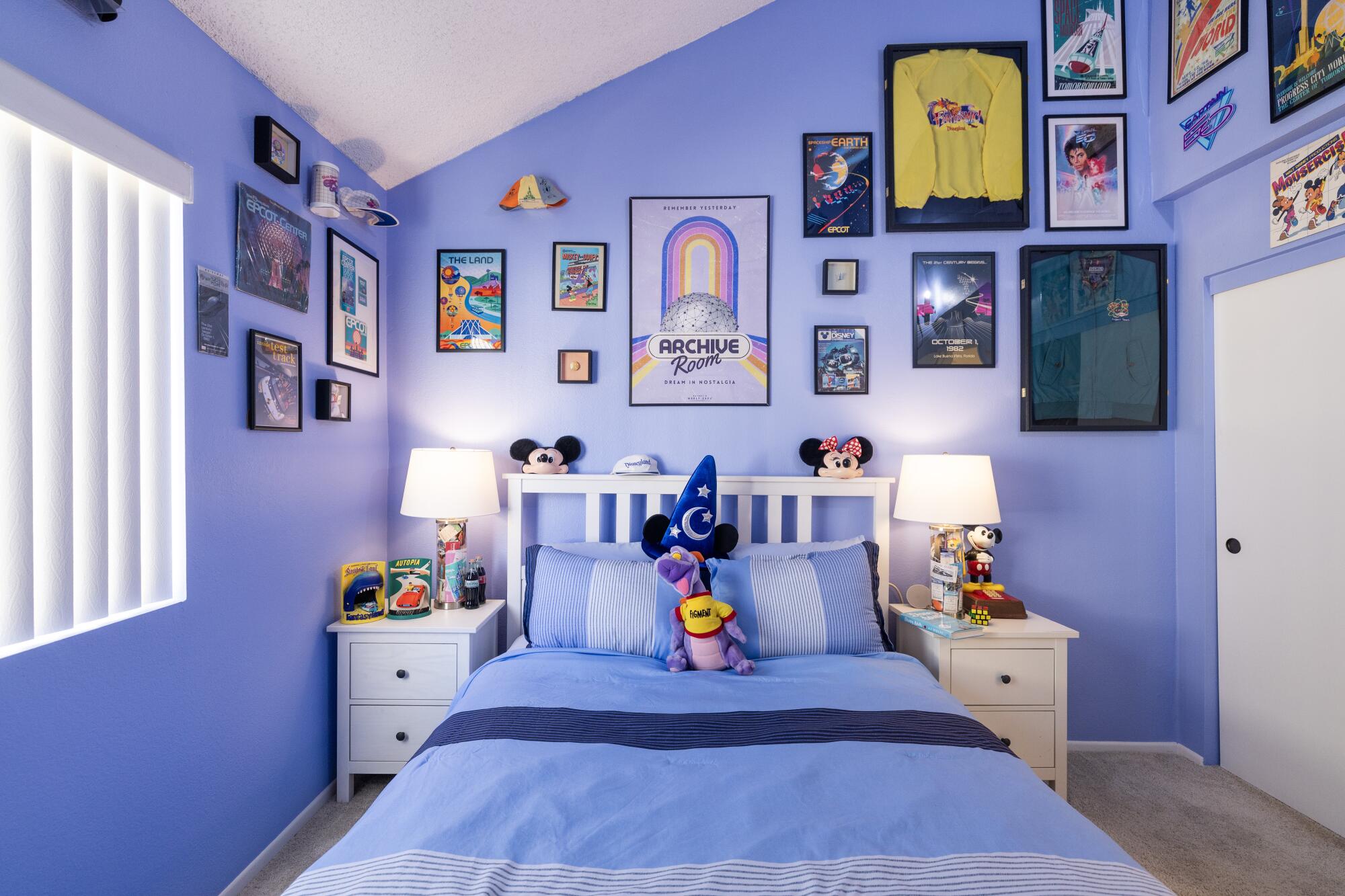 A blue bedroom with Disneyland memorabilia.