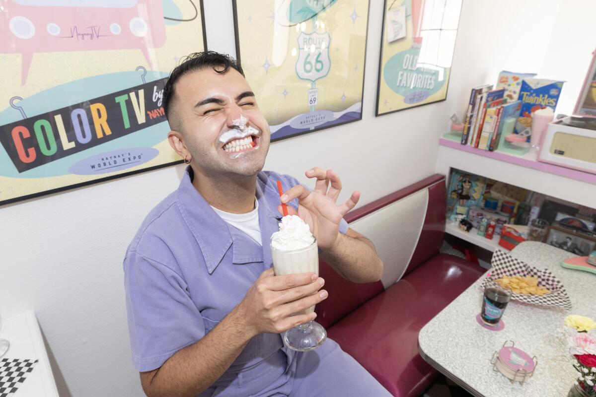 Brandon Shahniani holds a milkshake in his 1950s diner booth.