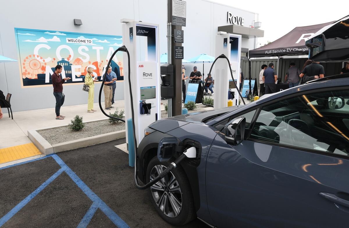 Guests stand next one of new Rove EV charging stations, and ReCharge by Gelson's micro market in Costa Mesa.