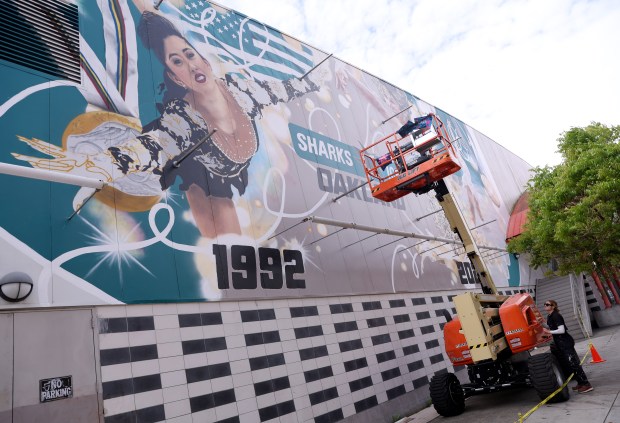 Artist Julie Engelmann, of Half Moon Bay, adjusts her lift as she works on her mural of Olympic gold medal figure skaters Alysa Liu and Kristi Yamaguchi at the Oakland Ice Center in Oakland, Calif., on Wednesday, April 15, 2026. Engelmann has worked on the mural since late March and it's nearly complete. (Jane Tyska/Bay Area News Group)