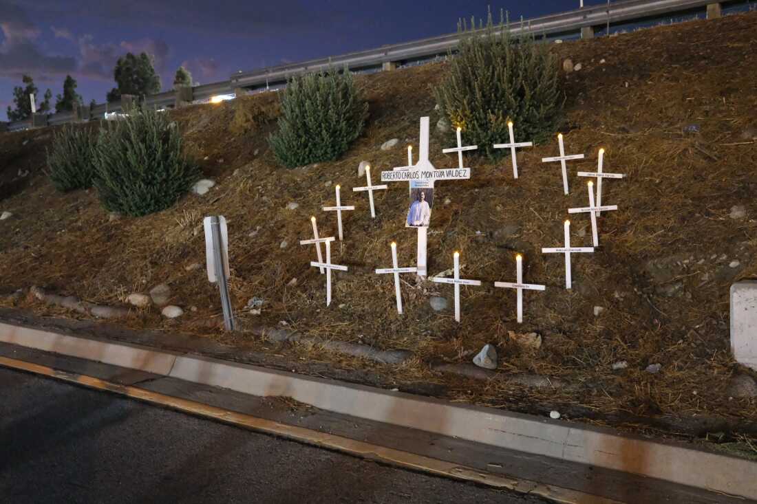 A memorial for Carlos Roberto Montoya Valdez (his first and second names are erroneously transposed on the cross). Activists said Montoya was killed while running across the freeway to escape an ICE raid of day laborers at the Home Depot parking lot across the street. Los Jornaleros — many of the band's members day laborers themselves — played at a memorial vigil for him.