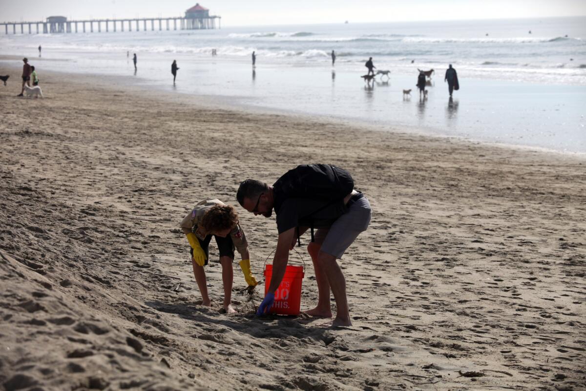Matt VanderMeer and his son Cordell VanderMeer, 11, from Huntington Beach take part in cleaning the shore line. 