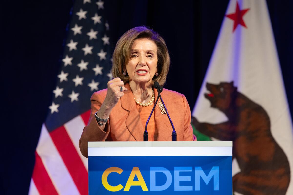 A woman speaks into microphones at a lectern.