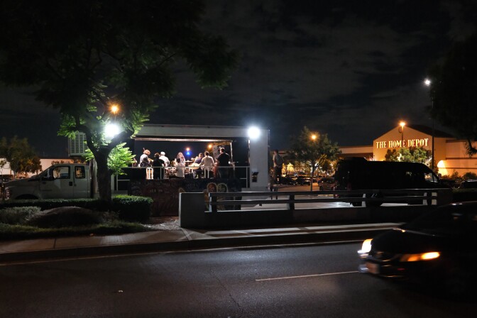 A band performs on the bed of a truck at night.