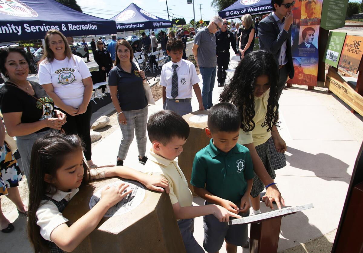 Students from the Blessed Sacrament School look at a panel exhibit on the Mendez Freedom Trail in Westminster on Tuesday.