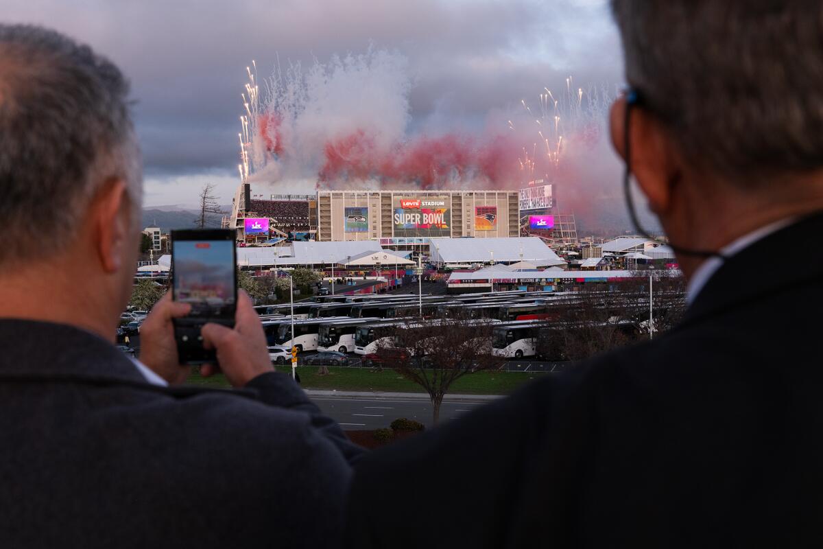 People watch fireworks during Bad Bunny’s halftime show from a parking garage outside Super Bowl LX at Levi’s Stadium in Santa Clara on Feb. 8, 2026. Photo by Jungho Kim for CalMatters