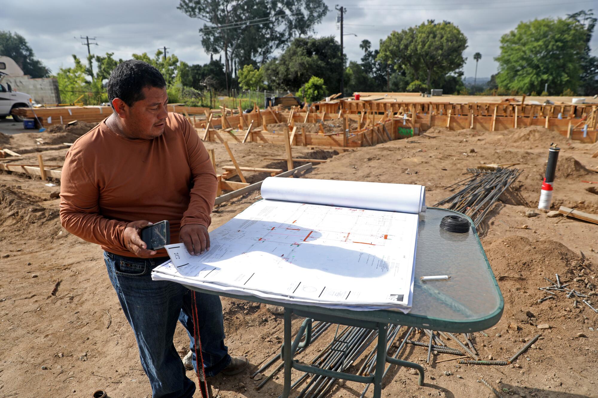Felipe Jimenez, foreman, looks at the plans for a new home under construction in Altadena