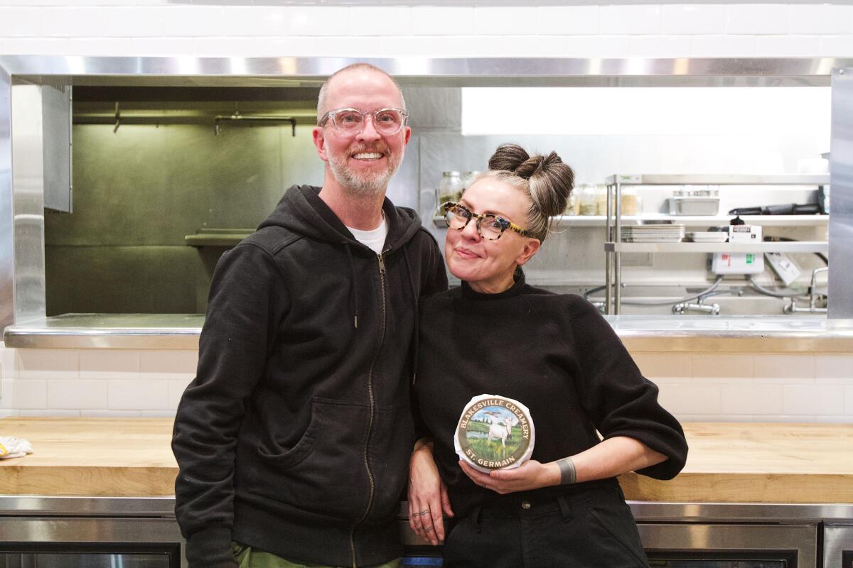 DTLA Cheese Superette partners Reed Herrick and Lydia Clarke stand in front of the kitchen at their new restaurant