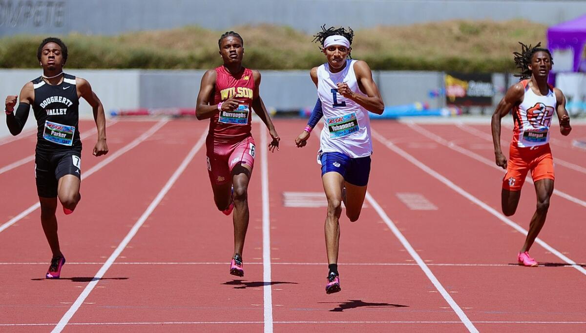 Loyola senior Ejam Yohannes (second from right) wins the Invitational 400 meters in 46.29 seconds.