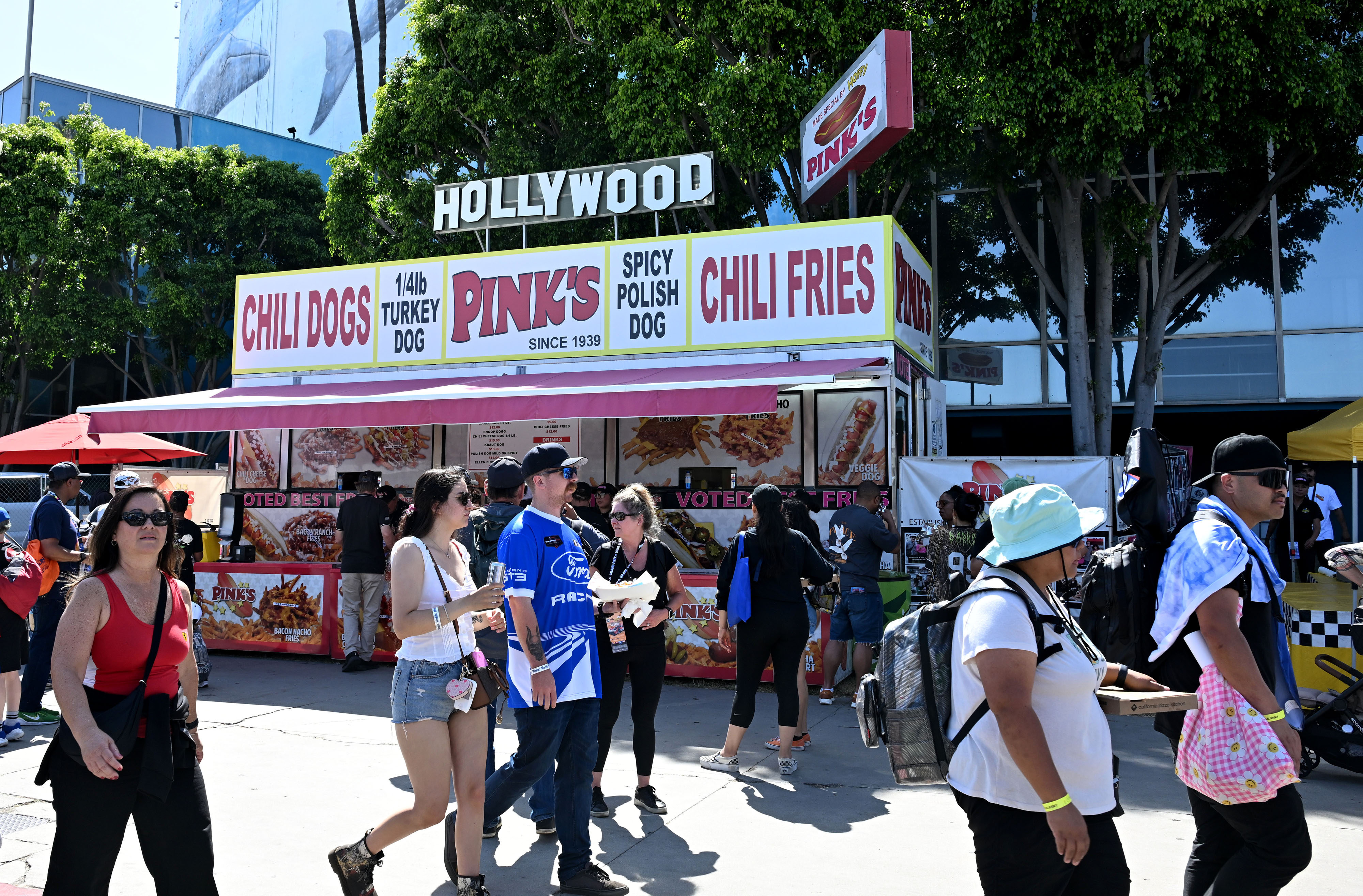Race fans pass the Pinks hot dog stand during the...