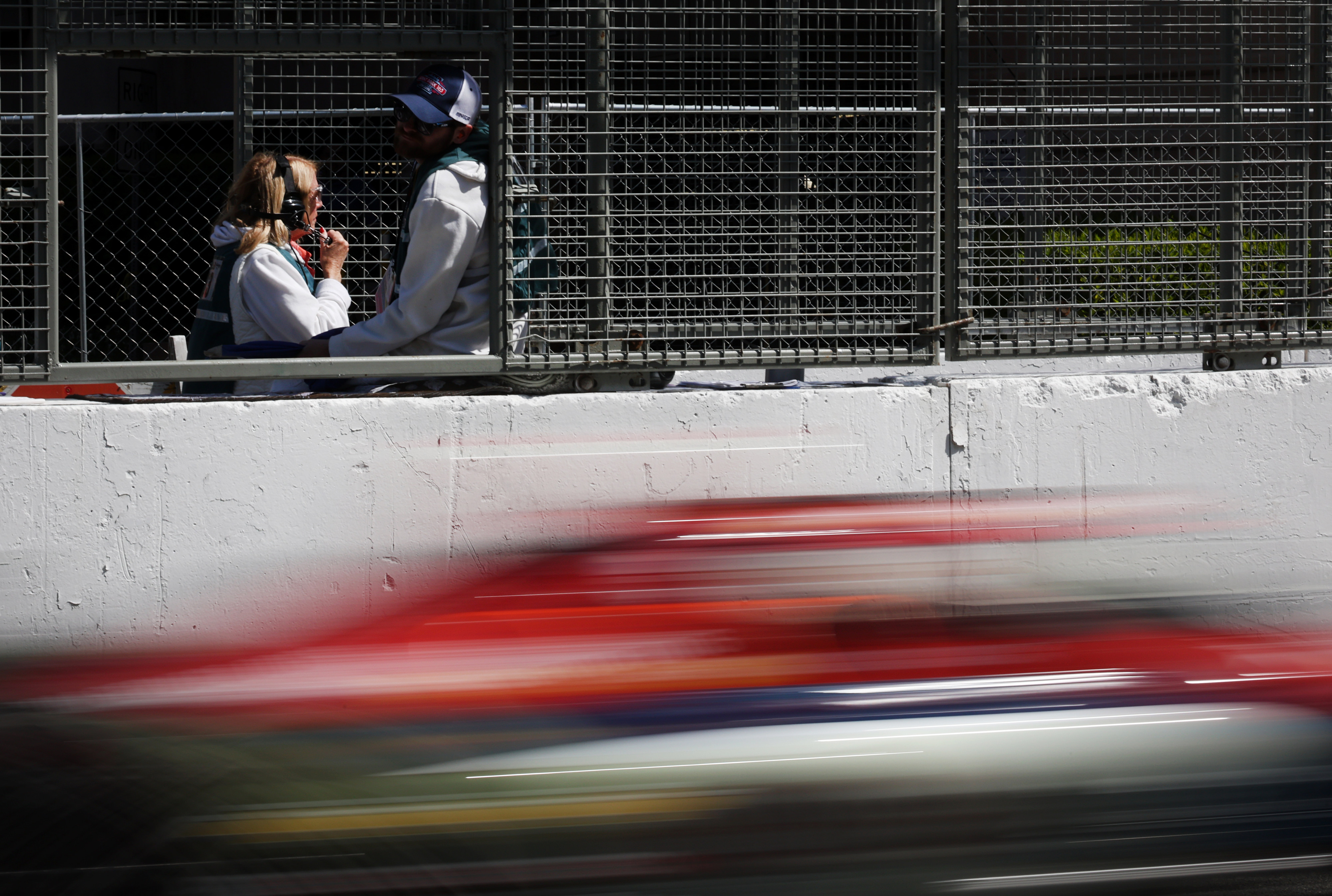 Trackside workers watch the second practice session for the NTT...