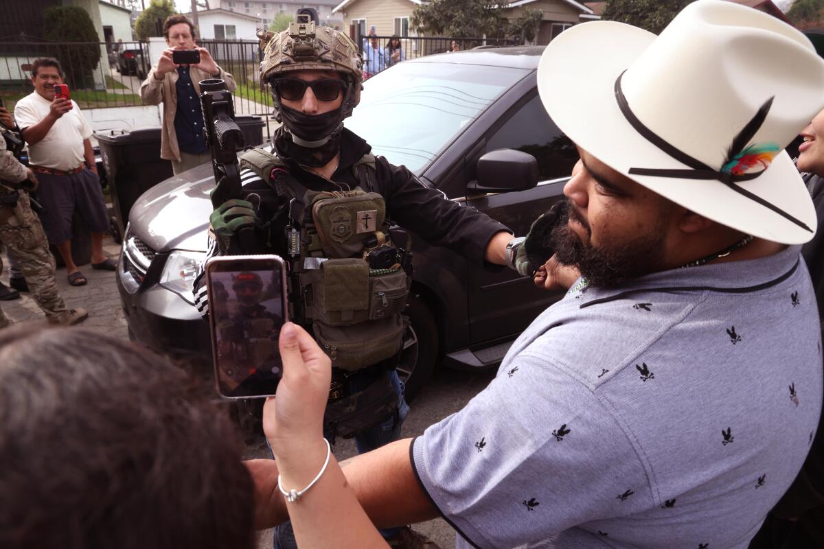 A Federal agent asks residents to move back at the scene of a shooting