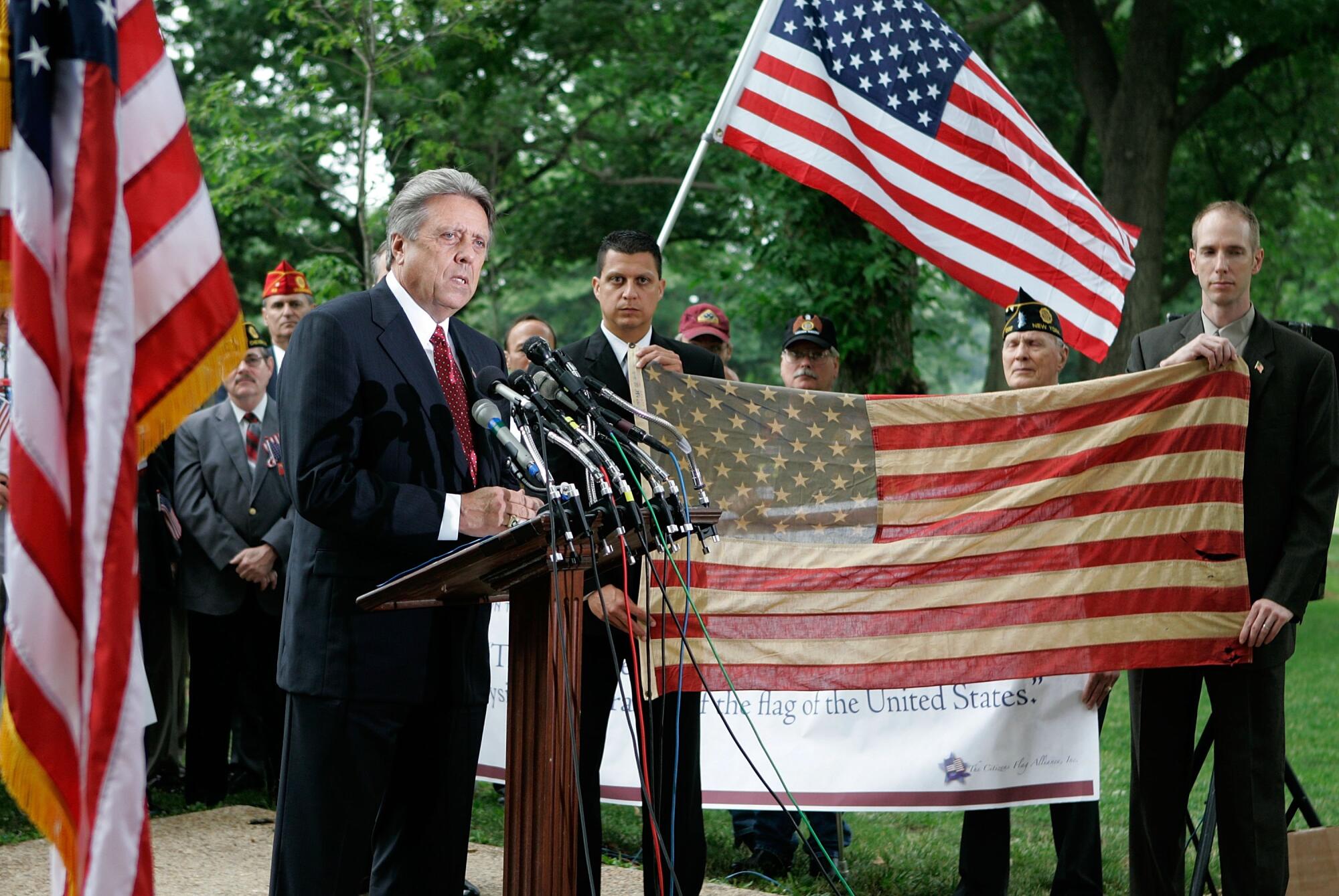 Rick Monday speaks while standing near a flag he rescued from being burnt at Dodger Stadium on Capitol Hill on June 14, 2006.