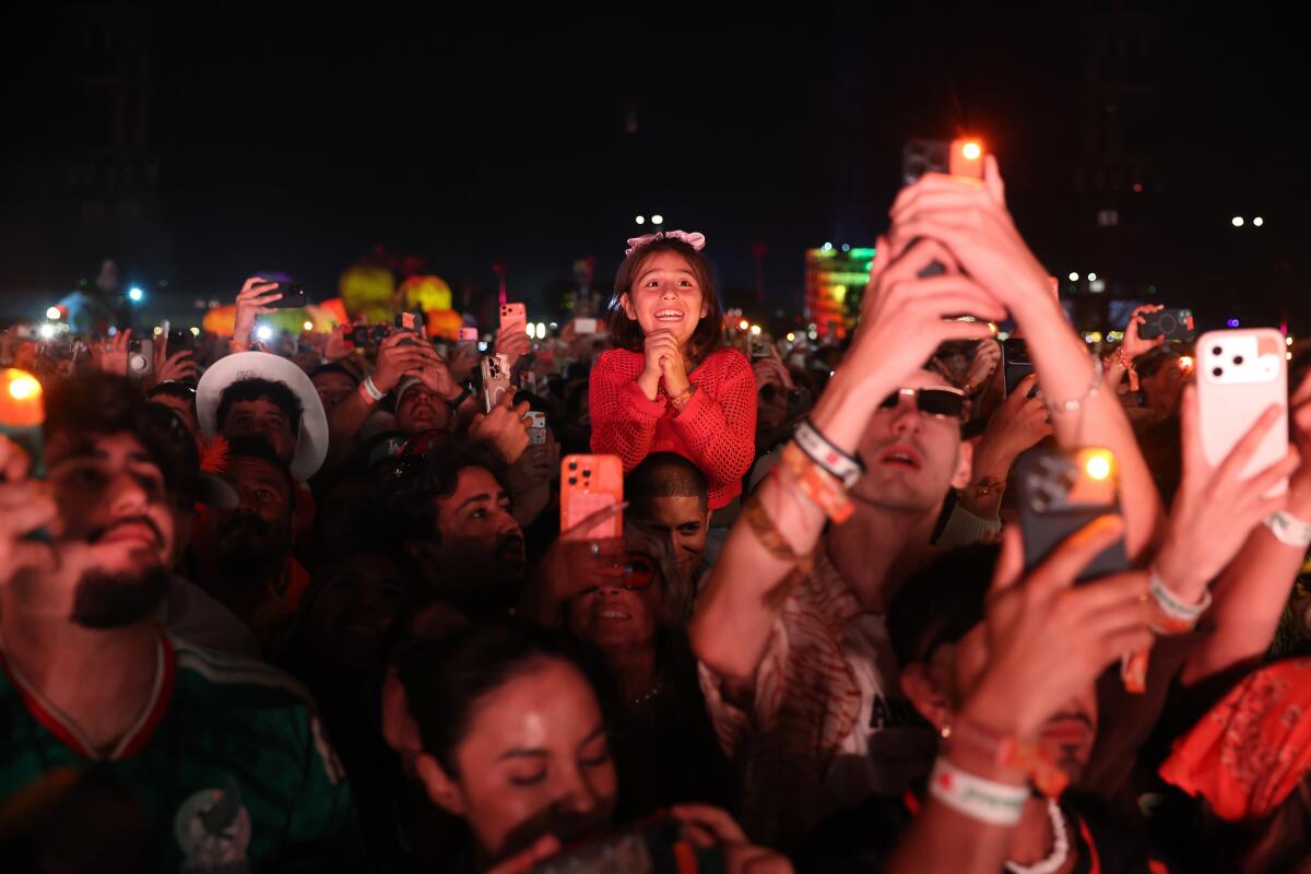 Fans hold up phones during a set at Coachella.