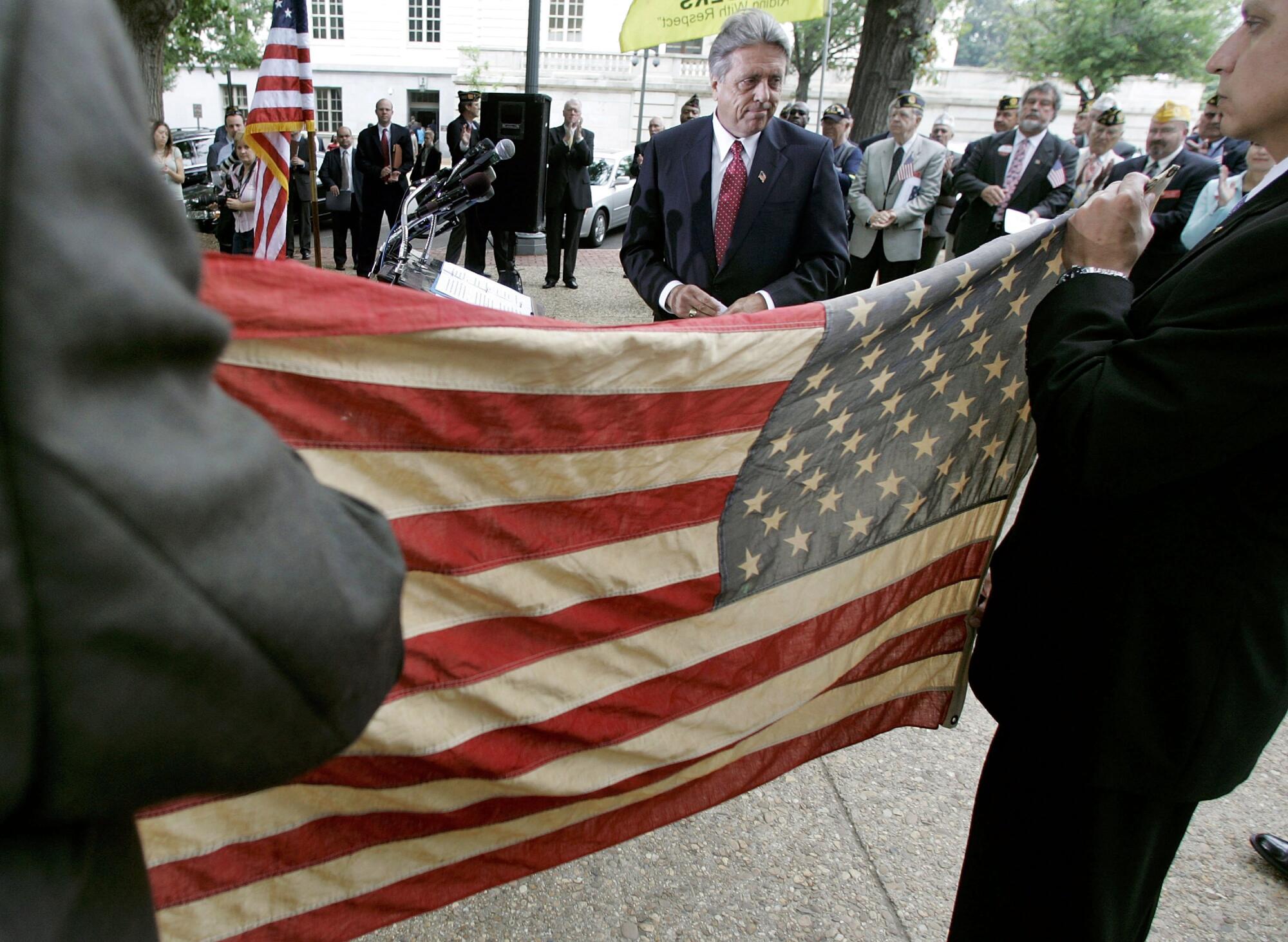 Rick Monday stands by a flag he rescued from being burnt at Dodger Stadium during a news conference on Capitol Hill in 2006.