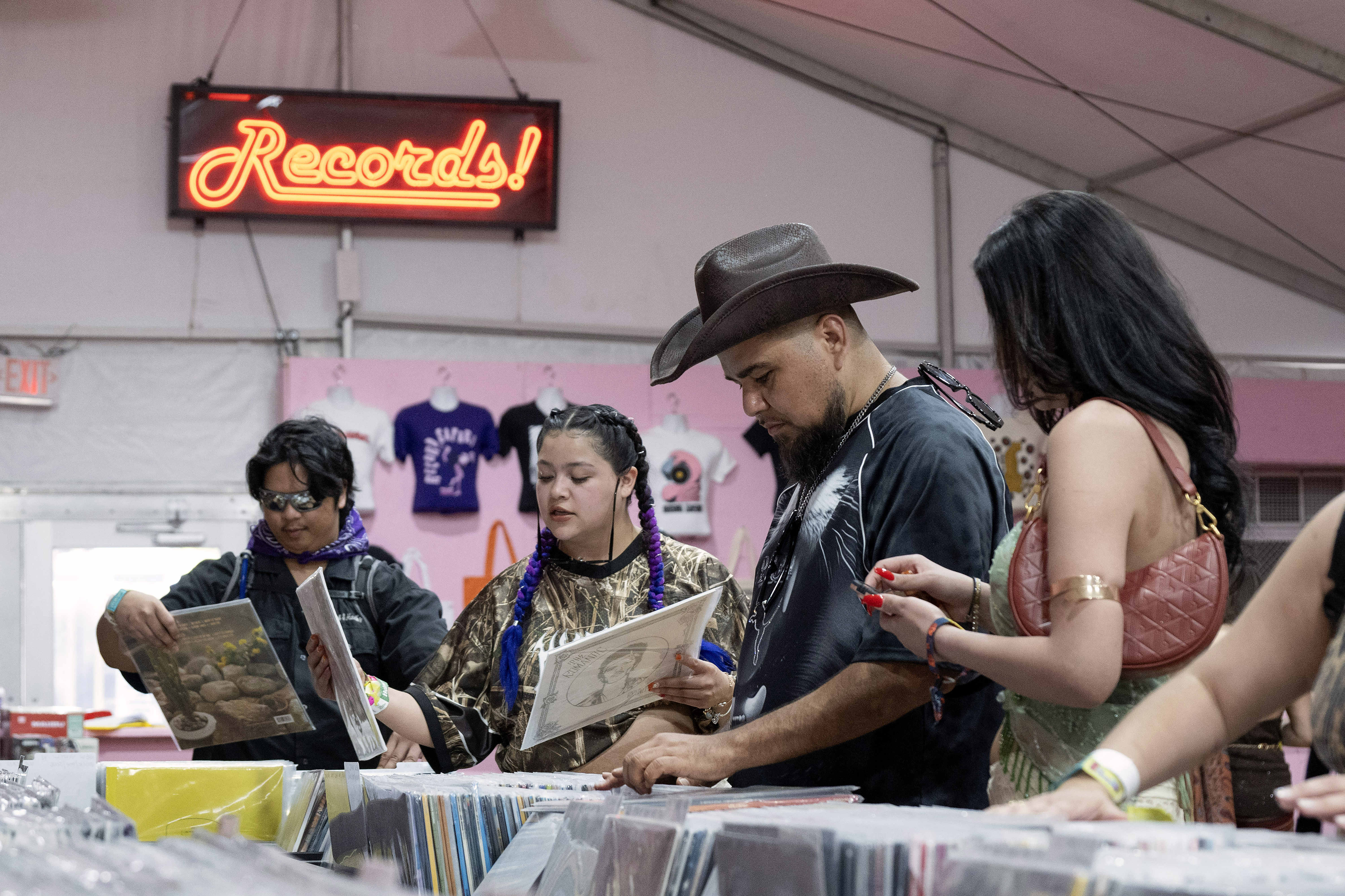 Arturo Cecena, second from right, shops for vinyl records inside...